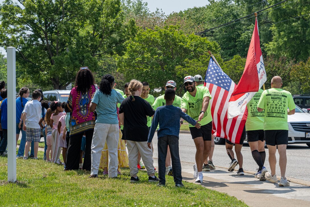 Runners high five children. (U.S. Air Force photo by Airman 1st Class Skylar Ellis)