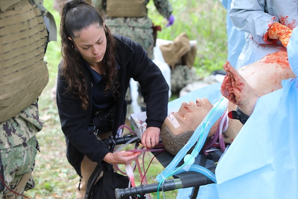 Kristen Andrade, Strategic Operations staff member, applies a simulated medical tubing to a high-fidelity trauma manikin during an Expeditionary Resuscitative Surgical System course at Naval Expeditionary Medicine Warfighter Development Center (NEMWDC), Apr. 14. The realistic wounds and outfits help immerse students in combat medical simulations and reinforce rapid trauma assessment skills. (U.S. Navy photo by Petty Officer 2nd Class Kwame Obengyeboah)