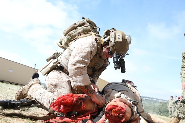 Special Operations Independent Duty Corpsman (SOIDC) Hospital Corpsman 1st Class Nichola Farris, with 1st Reconnaissance Battalion, applies a tourniquet to a simulated casualty during an Expeditionary Resuscitative Surgical System (ERSS) course at Naval Expeditionary Medicine Warfighter Development Center (NEMWDC), Apr. 14. The scenario incorporates realistic moulage, role players, and battlefield effects, integrating EXMED platforms with operational units to enhance trauma response and prepare medical personnel for operational deployment in an austere environments.  (U.S. Navy photo by Petty Officer 2nd Class Moira Francine Esquivel)