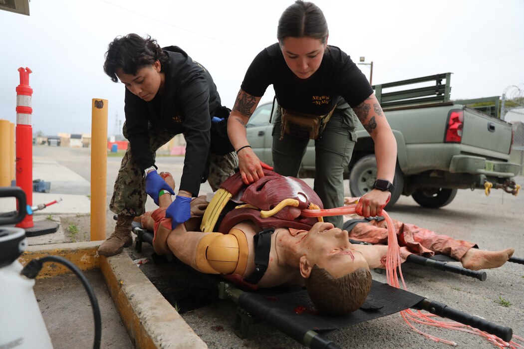 Hospital Corpsman 2nd Class Angela Solis (left) and Hospital Corpsman 3rd Class Abbigail Dunlap (right), moulage technicians with Naval Expeditionary Medicine Warfighter Development Center (NEMWDC), prepares a high-fidelity surgical manikin by loading simulated organs into the chest and putting on a cut suit during an Expeditionary Resuscitative Surgical System course at NEMWDC, Apr. 14. Solis expresses, “I believe realistic moulage plays a critical role in medical simulations because it helps bridge the gap between textbook knowledge and real-world application. It enhances the students’ ability to recognize injury patterns and apply appropriate treatment algorithm more intuitively.” (U.S. Navy photo by Petty Officer 2nd Class Moira Francine Esquivel)