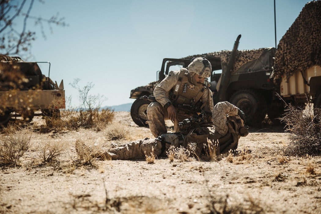 U.S. Navy Hospitalman 2nd Class Antonio Garcia, a Harlingen, Texas native, hospital corpsman with 3rd Battalion, 14th Marine Regiment, 4th Marine Division, provides medical attention to a simulated casualty during a Marine Air-Ground Task Force Warfighting Exercise at MCAGCC, Twentynine Palms, California, Feb. 20, 2025.  MWX is a comprehensive force-on-force training event designed to enhance the operational readiness and combat effectiveness of all MAGTF elements by simulating complex and dynamic battle scenarios while refining tactics. Service Level Training Exercise 1-25 is purpose built to increase readiness across Core Mission Essential Tasks, preparing composite task forces for force-on-force operations across a contested multi-domain distributed environment through modern training tools and data capture.  (U.S. Marine Corps photo by Lance Cpl. Richard PerezGarcia)