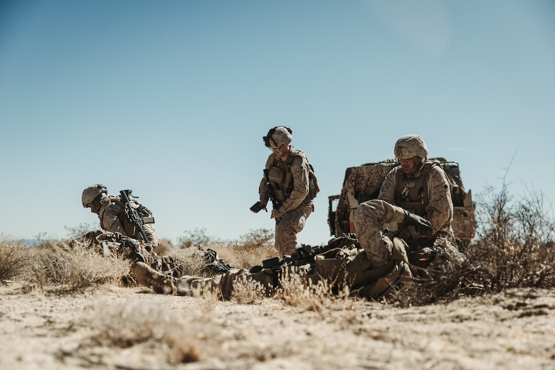 U.S. Navy Hospital Corpsmen with 3rd Battalion, 14th Marine Regiment, 4th Marine Division, provide medical attention to simulated casualties during a Marine Air-Ground Task Force Warfighting Exercise at MCAGCC, Twentynine Palms, California, Feb. 20, 2025.  MWX is a comprehensive force-on-force training event designed to enhance the operational readiness and combat effectiveness of all MAGTF elements by simulating complex and dynamic battle scenarios while refining tactics. Service Level Training Exercise 1-25 is purpose built to increase readiness across Core Mission Essential Tasks, preparing composite task forces for force-on-force operations across a contested multi-domain distributed environment through modern training tools and data capture.  (U.S. Marine Corps photo by Lance Cpl. Richard PerezGarcia)