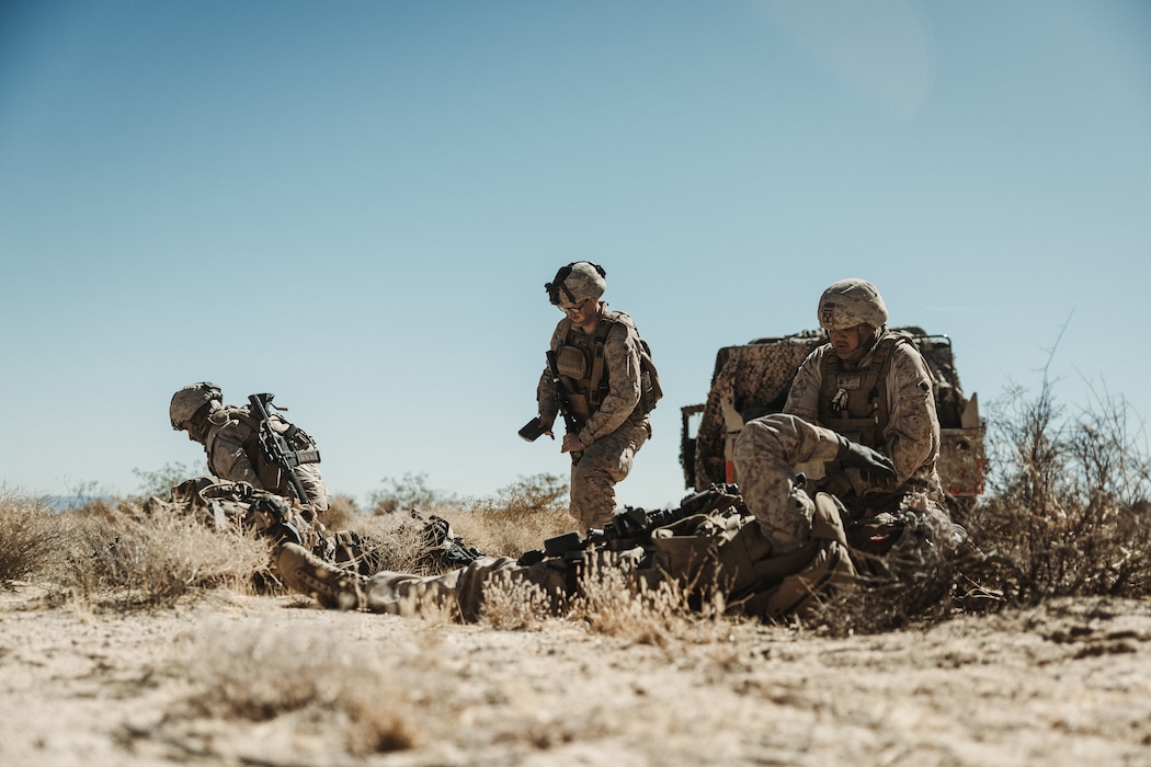 U.S. Navy Hospital Corpsmen with 3rd Battalion, 14th Marine Regiment, 4th Marine Division, provide medical attention to simulated casualties during a Marine Air-Ground Task Force Warfighting Exercise at MCAGCC, Twentynine Palms, California, Feb. 20, 2025.  MWX is a comprehensive force-on-force training event designed to enhance the operational readiness and combat effectiveness of all MAGTF elements by simulating complex and dynamic battle scenarios while refining tactics. Service Level Training Exercise 1-25 is purpose built to increase readiness across Core Mission Essential Tasks, preparing composite task forces for force-on-force operations across a contested multi-domain distributed environment through modern training tools and data capture.  (U.S. Marine Corps photo by Lance Cpl. Richard PerezGarcia)