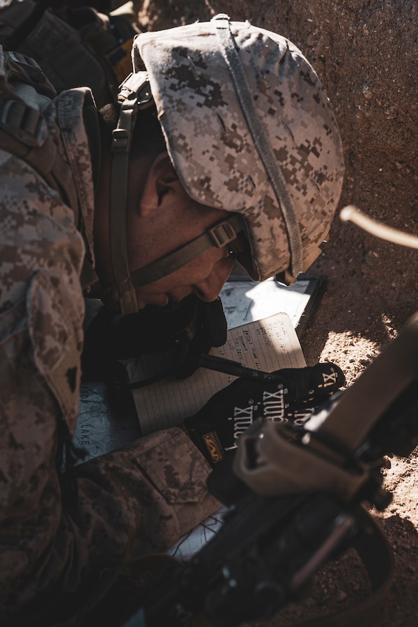 U.S. Marine Corps Cpl. Miguel Ramirez, a Huntington Beach, California native, fire support Marine with 5th Battalion, 14th Marine Regiment, 4th Marine Division, documents the impact of rounds during a Fire Support Coordination Exercise as part of Service Level Training Exercise 0-25 at Training Area Quackenbush, Marine Corps Air-Ground Combat Center, Twentynine Palms, California, Dec. 6, 2024. FSCEX is a live-fire training event integrating infantry battalion combat operations center functions, distributed artillery, mobile fire support teams, close air support assets, and electronic warfare support teams. SLTE 0-25 is designed to enhance readiness across core Mission Essential Tasks and prepare Marines for Force-on-Force operations.  (U.S. Marine Corps photo by Lance Cpl. Enge You)