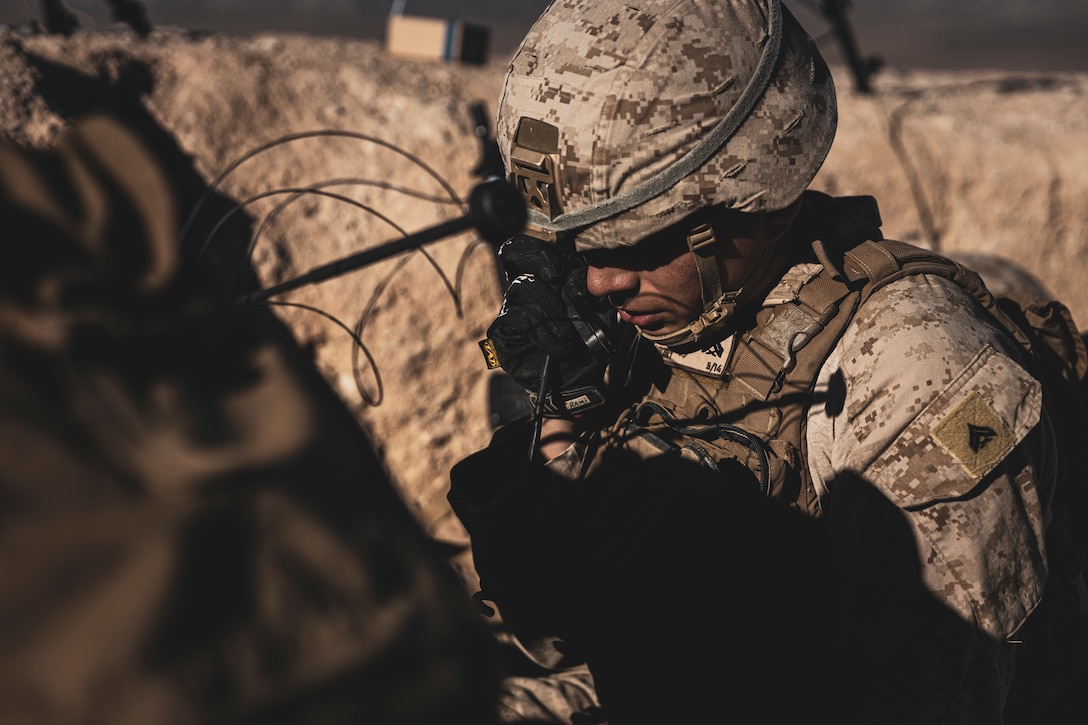 U.S. Marine Corps Cpl. Miguel Ramirez, a Huntington Beach, California native, fire support Marine with 5th Battalion, 14th Marine Regiment, 4th Marine Division, talks on the radio during a Fire Support Coordination Exercise as part of Service Level Training Exercise 0-25 at Training Area Quackenbush, Marine Corps Air-Ground Combat Center, Twentynine Palms, California, Dec. 6, 2024. FSCEX is a live-fire training event integrating infantry battalion combat operations center functions, distributed artillery, mobile fire support teams, close air support assets, and electronic warfare support teams. SLTE 0-25 is designed to enhance readiness across core Mission Essential Tasks and prepare Marines for Force-on-Force operations.  (U.S. Marine Corps photo by Lance Cpl. Enge You)