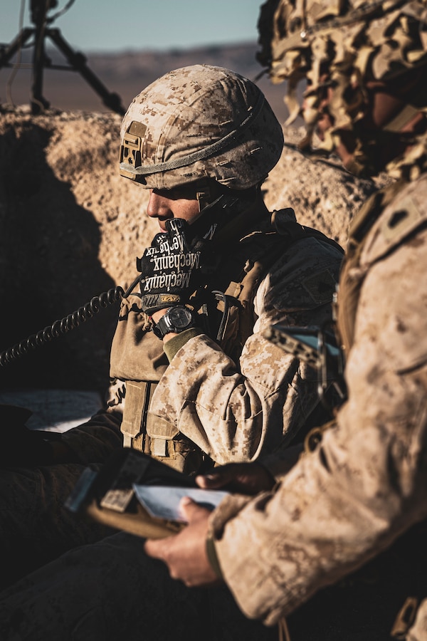 U.S. Marine Corps Cpl. Miguel Ramirez, a Huntington Beach, California native, fire support Marine with 5th Battalion, 14th Marine Regiment, 4th Marine Division, talks on the radio during a Fire Support Coordination Exercise as part of Service Level Training Exercise 0-25 at Training Area Quackenbush, Marine Corps Air-Ground Combat Center, Twentynine Palms, California, Dec. 6, 2024. FSCEX is a live-fire training event integrating infantry battalion combat operations center functions, distributed artillery, mobile fire support teams, close air support assets, and electronic warfare support teams. SLTE 0-25 is designed to enhance readiness across core Mission Essential Tasks and prepare Marines for Force-on-Force operations.  (U.S. Marine Corps photo by Lance Cpl. Enge You)