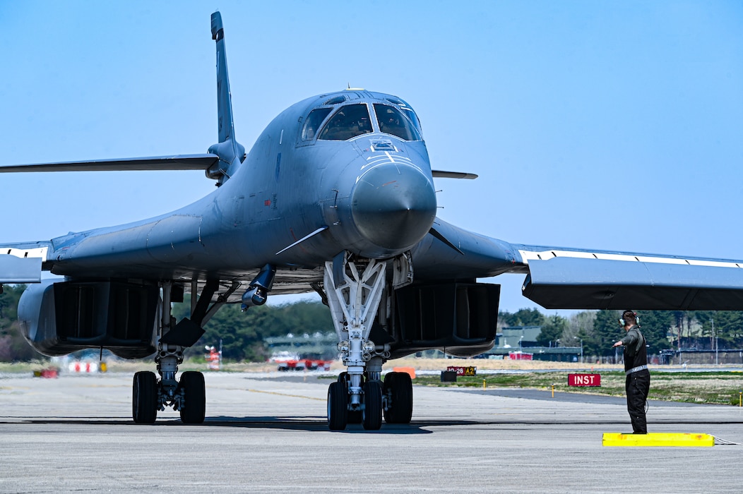 U.S. Air Force Senior Airman Colby Delia, 9th Expeditionary Bomb Squadron crew chief, marshals a B-1B Lancer on a flight line during Bomber Task Force 25-2 at Misawa Air Base, Japan, May 3, 2025.