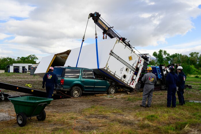 Members of the Missile Mishap Recovery Team lifts an overturned trailer off a vehicle during a training event in Ogden, Utah, May 5, 2025. With exception to the warhead, the MMRT responds to Minuteman III situations that fall out of the scope of tech data and standard procedures or pose significant hazards. The highly specialized team is the only one in the Air Force. (U.S. Air Force photo by R. Nial Bradshaw)