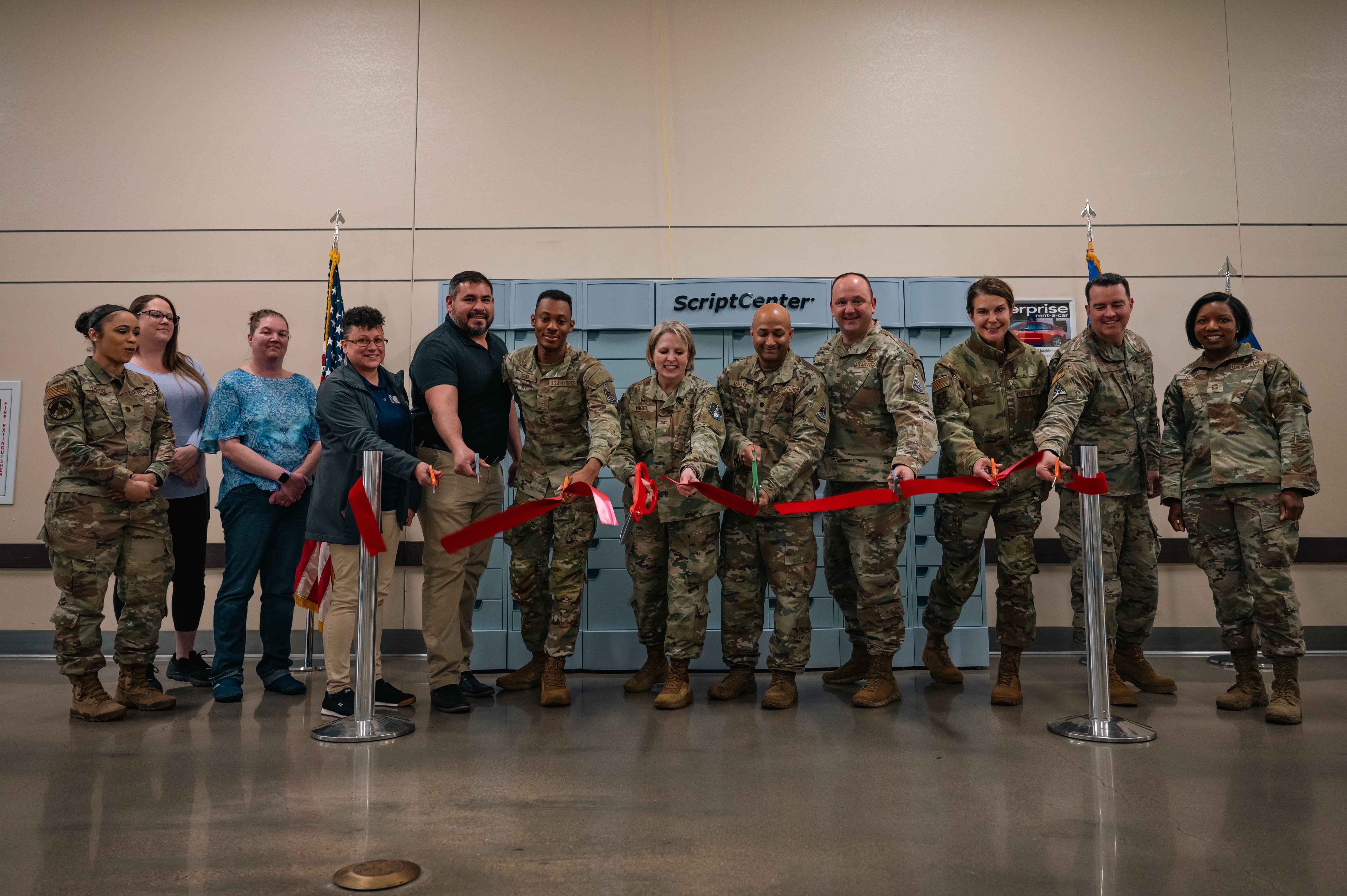Service members from Space Base Delta 2 cut a ribbon during a ScriptCenter ribbon cutting ceremony at Buckley Space Force Base, CO., May 6, 2025. The ScriptCenter kiosk is a state-of-the-art technology that will provide a convenient and secure location to pick up subscriptions. (U.S. Space Force photo by Staff Sgt. Danielle McBride)