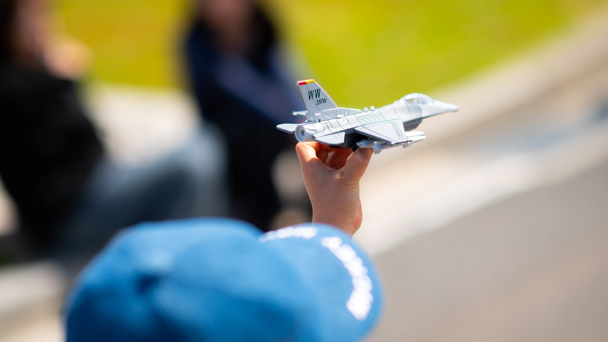 plastic toy of a fighter jet held in a boy's hand