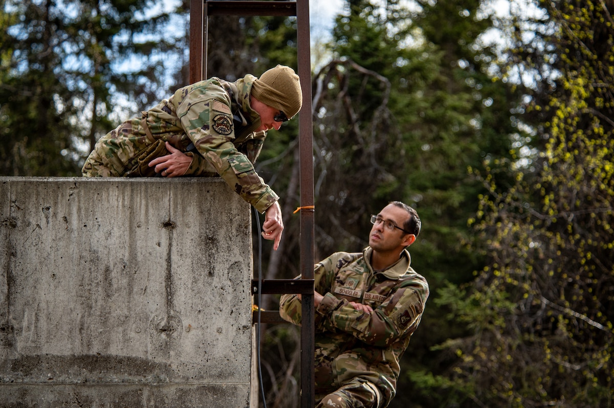 U.S. Air Force Master Sgt. Samuel Weaver (left), a first sergeant assigned to the 734 Air Mobility Squadron from Andersen Air Force Base, Guam, and Master Sgt. Isaac Schooler (right), a first sergeant assigned to the 18th Security Forces Squadron from Kadena Air Base, Japan, set up communications equipment at Camp Madbull during the first-ever Pacific Air Forces First Sergeant Readiness Summit on Joint Base Elmendorf-Richardson, Alaska, May 6, 20251. The summit brought more than 100 first sergeants from various major commands to put first sergeant responsibilities into action and improve their combat readiness. (U.S. Air Force photo by Airman 1st Class Hunter Hites)