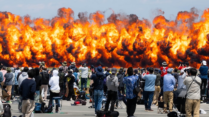airshow pyrotechnics launch fireballs into the air in front of an audience