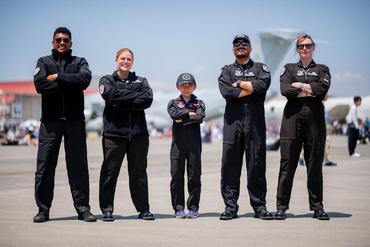 Demo team members pose with a Japanese boy for a group photo
