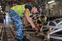 Royal Australian Airman pushes cargo.