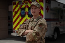 Airmen stands in front of an ambulance.