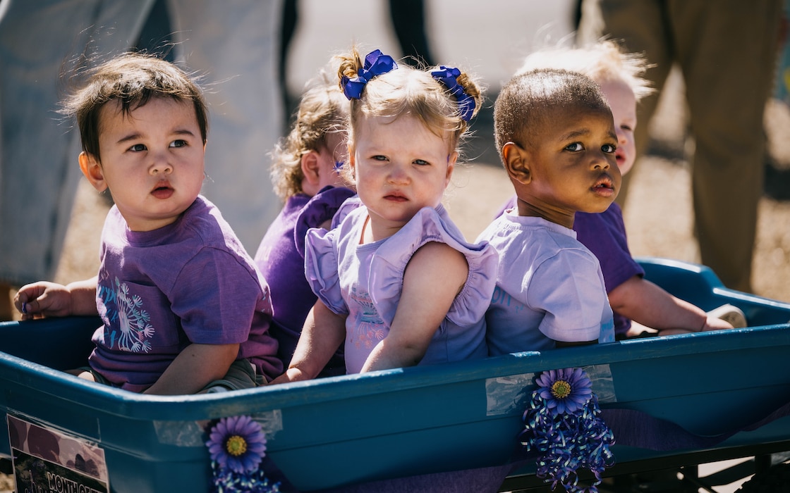 Children from the Luke Air Force Base Child Development Center sit in a wagon during the Purple Up parade, April 25, 2025, at Luke Air Force Base, Arizona.
