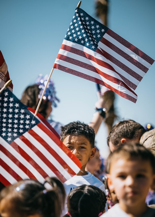 A child from the Luke Air Force Base Child Development Center waves an American flag during the Purple Up parade, April 25, 2025, at Luke Air Force Base, Arizona.