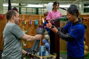 U.S. Air Force and JASDF representatives work together to light a torch.