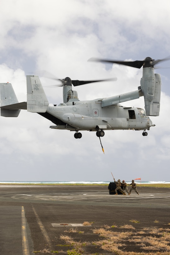 U.S. Marines with 3d Littoral Logistics Battalion, 3d Marine Littoral Regiment, 3d Marine Division, prepare to connect a cargo load to an MV-22 Osprey during helicopter support team training on Marine Corps Base Hawaii, April 3, 2024. HST training provides Marines the opportunity to refine the skills needed for completing external lifts to transport equipment and supplies from one location to another. (U.S. Marine Corps photo by Sgt. Jacqueline C. Parsons)