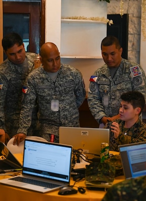 U.S. Marine Corps Cpl. Tristen Davis, right, a cyber warfare defense operator of Marine Corps Cyberspace Operations Group, exchanges cyber defense tactics and procedures with Armed Forces of the Philippines service members during a Cyber Defense Exercise in support of Exercise Balikatan 25 at Camp Aguinaldo, Manila, Philippines, April 24, 2025.
