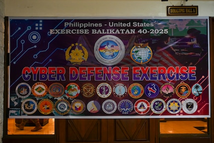 A banner depicting the participants of the Cyber Defense Exercise hangs in support of Exercise Balikatan 25 at Camp Aguinaldo, Manila, Philippines, April 24, 2025.