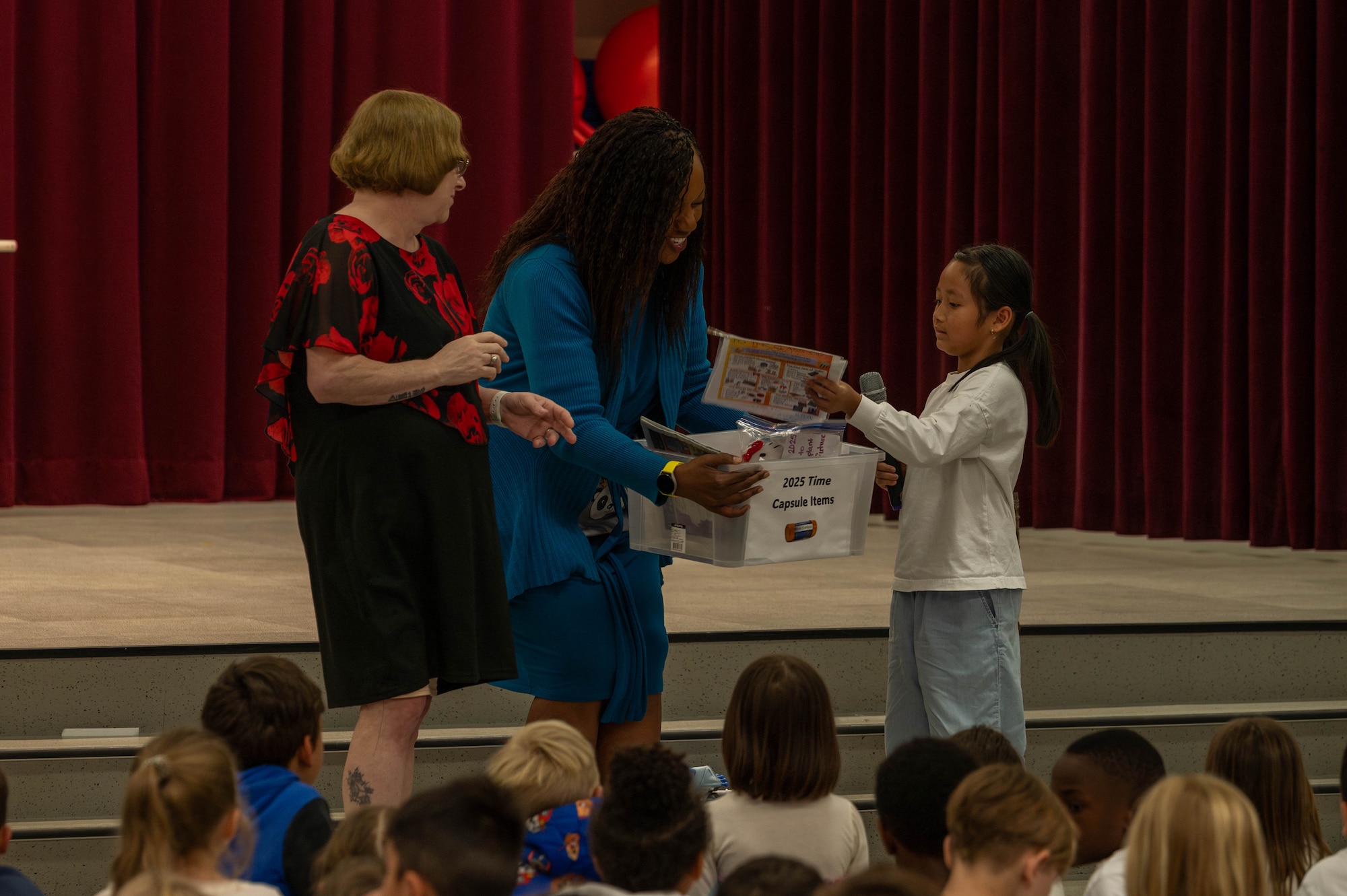 A student from Mendel Elementary School places an item into the time capsule.