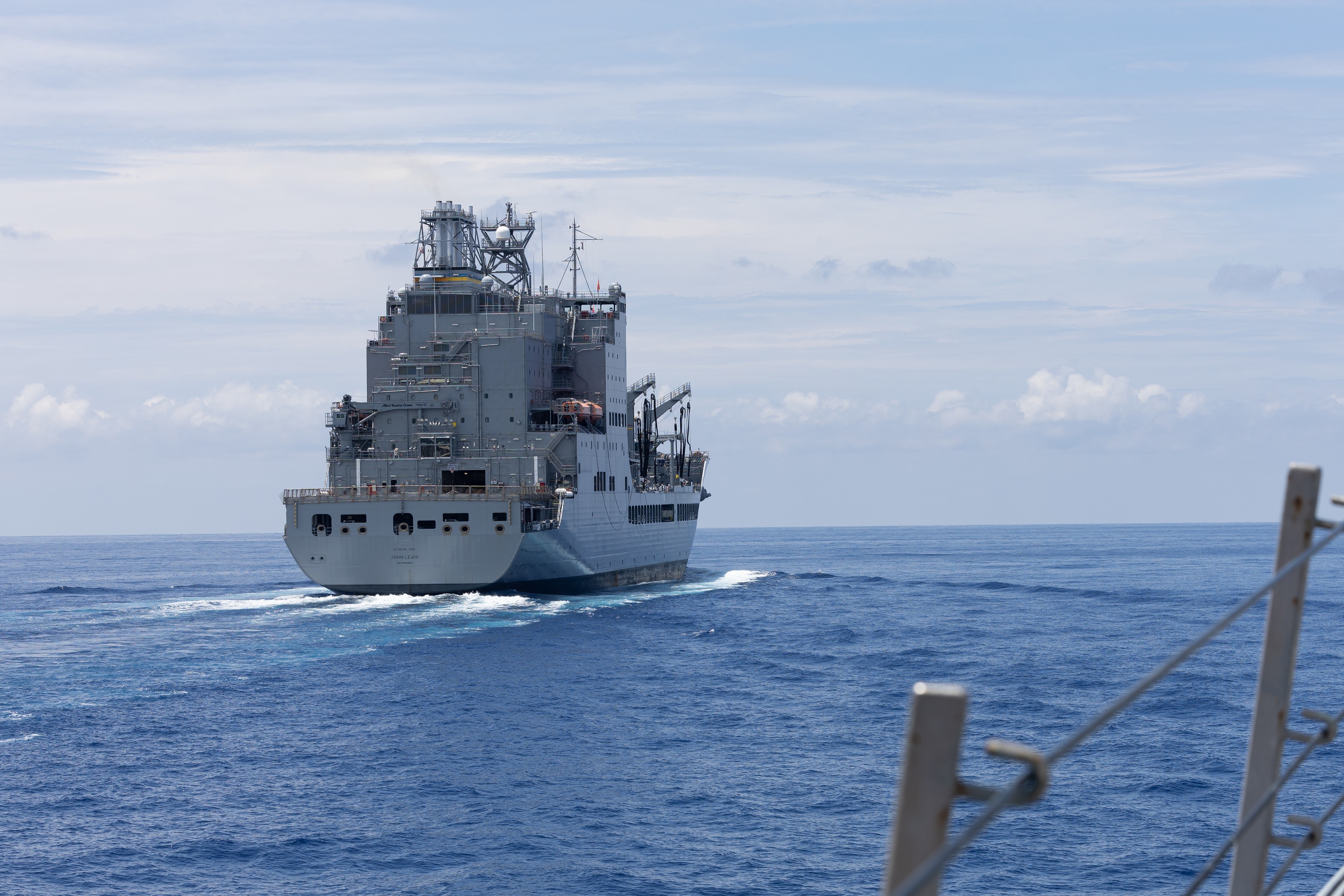The Arleigh Burke-class guided-missile destroyer USS Curtis Wilbur (DDG 54) pulls alongside the fleet replenishment oiler USNS John Lewis (T-AO 205) for a replenishment-at-sea in the South China Sea, May 6, 2025. The Curtis Wilbur, assigned to the Nimitz Carrier Strike Group, is underway in the U.S. 7th Fleet area of operations on a scheduled deployment, demonstrating the U.S. Navy’s unwavering commitment to a free and open Indo-Pacific. (U.S. Navy photo by Mass Communication Specialist Seaman Apprentice Mark Bergado)