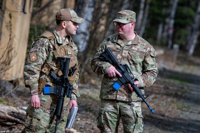 U.S. Air Force Tech. Sgt. Justin Pena (left), a defender assigned to the 673d Security Forces Squadron, and Master Sgt. Kenneth Tussey (right), a first sergeant assigned to the 354th Munitions Squadron from Eielson Air Force Base, Alaska, set up a defensive perimeter at Camp Madbull during the first-ever Pacific Air Forces First Sergeant Readiness Summit at Joint Base Elmendorf-Richardson, Alaska, May 6, 2025. The summit brought more than 100 first sergeants from various major commands to put first sergeant responsibilities into action and improve their combat readiness. (U.S. Air Force photo by Airman 1st Class Hunter Hites)