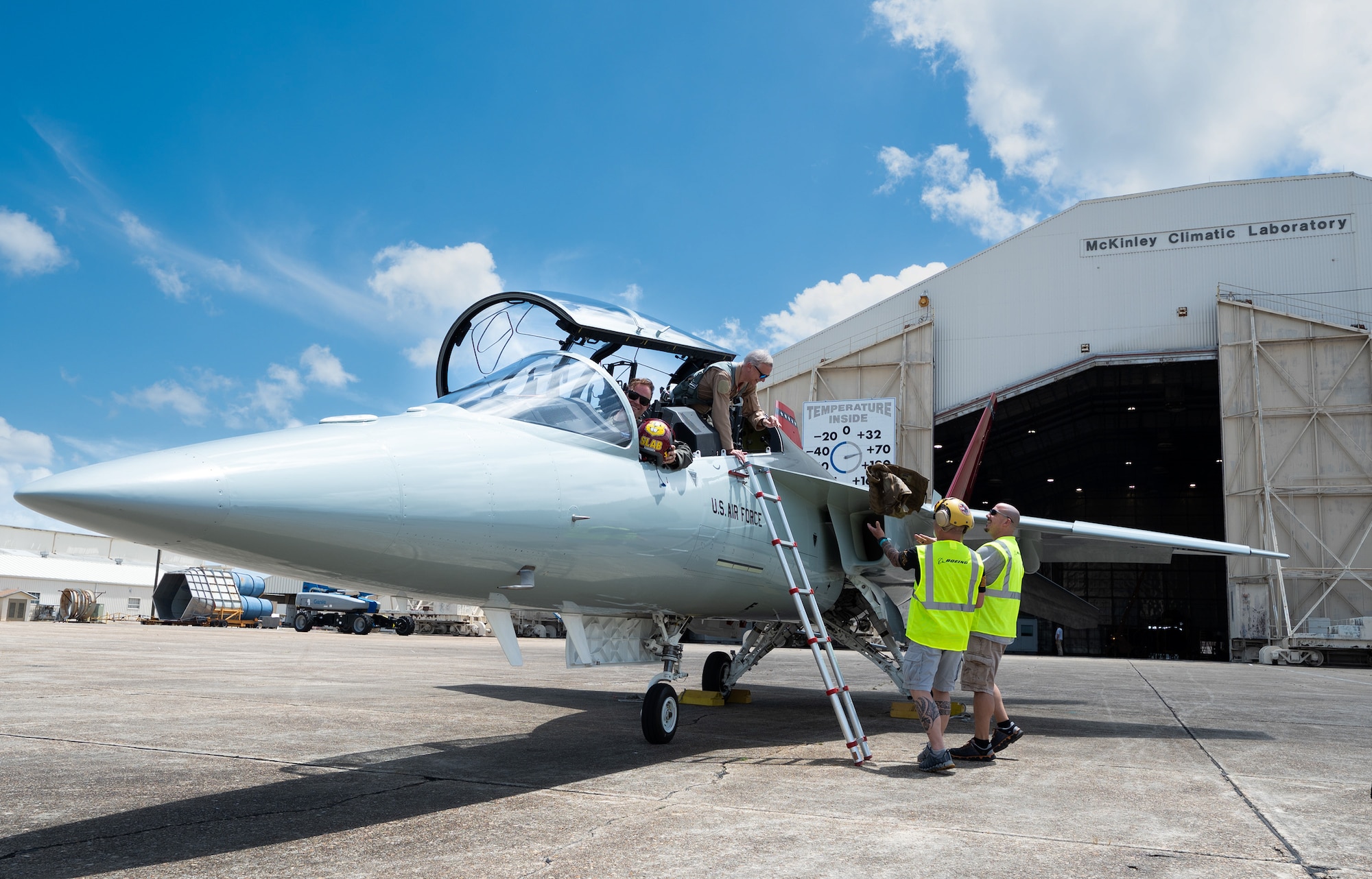 Air crew members assist pilots off-boarding a T-7A Red Hawk
