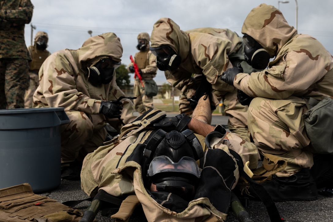 U.S. Marines and Sailors assess a simulated casualty during a Chemical, Biological, Radiological, Nuclear Monitor, Surveillance, and Decontamination certification course at Camp Hansen, Okinawa, Japan, Feb. 28, 2025. Service members with 12th Littoral Anti-Air Battalion trained with CBRN specialists to enhance their skills in threat recognition, equipment use, and decontamination procedures. The training focused on team monitoring, surveying, and responding to different simulated airborne and absorbent hazardous attacks. The service members are with 12th LAAB, 12th Marine Littoral Regiment, 3d Marine Division. (U.S. Marine Corps photo by Cpl. John Simpson)