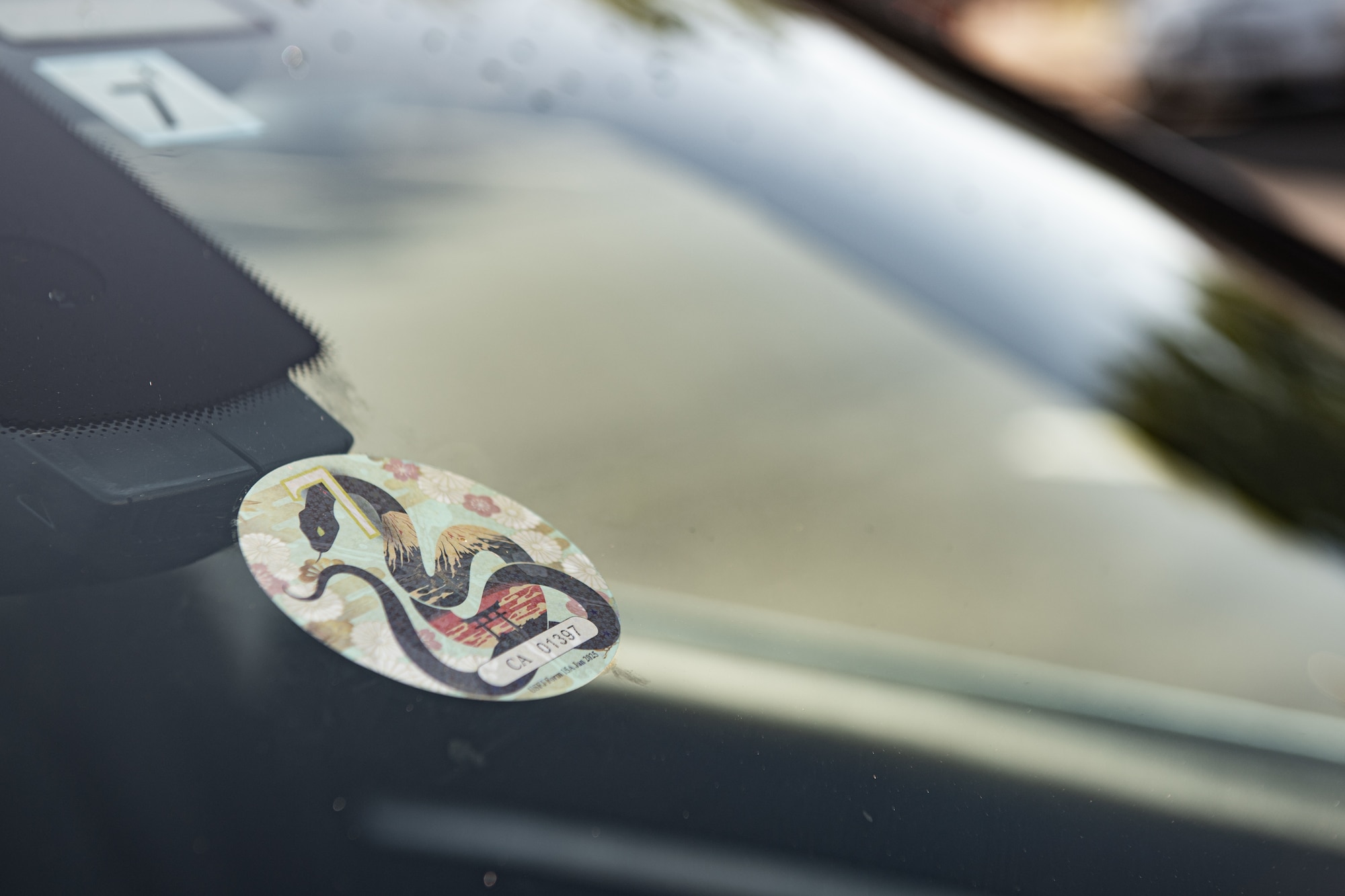 A 2025 Road Tax Rodeo window decal is displayed on the front windshield of a car.
