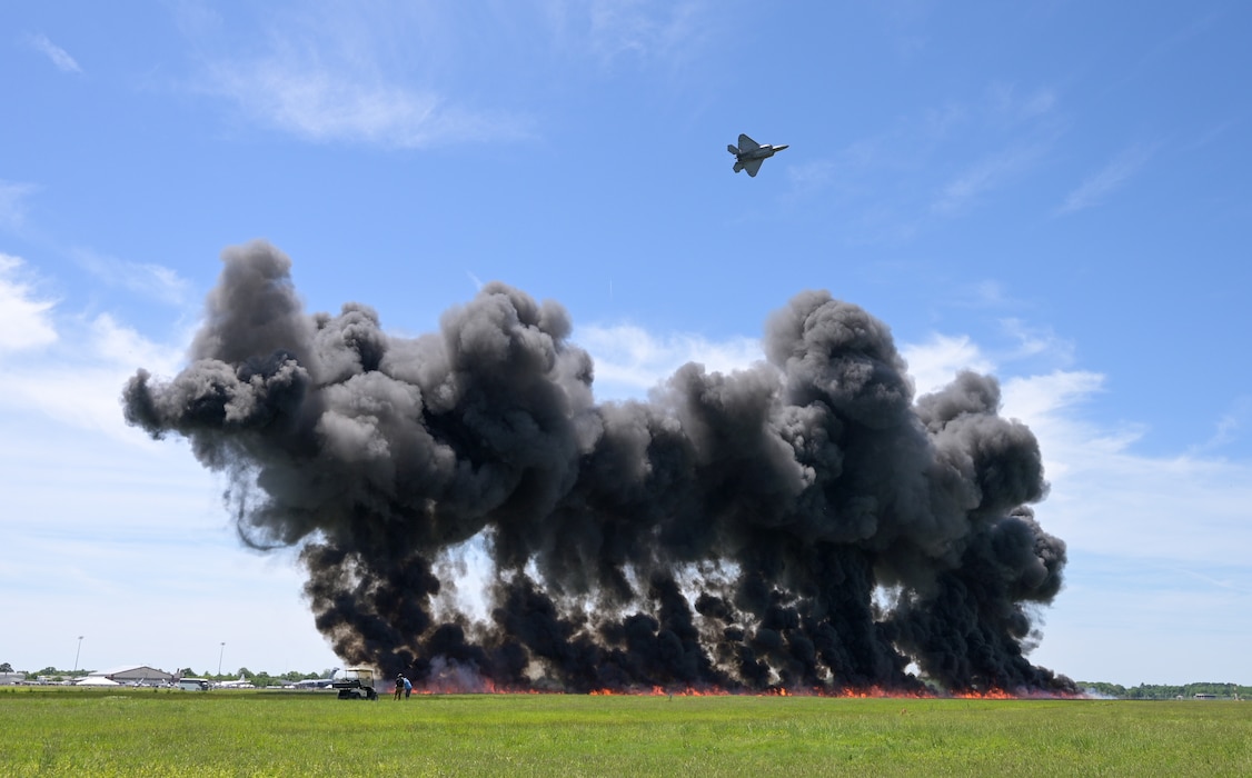 F-22 flying over fire and smoke