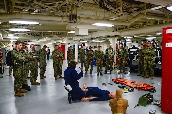 U.S. Navy Sailors assigned to Casualty Receiving Transport Ship 2 and CRTS-6 from Navy Medicine Readiness and Training Command San Diego receive learn shipboard patient transport aboard USS Tripoli (LHA 7) while conducting Amphibious Familiarization Training, May 7, 2025. Shipboard familiarization increases operational readiness within the Pacific Fleet and expedtionary medicine worldwide. The mission of NMCSD is to provide a superior experience for our patients, staff, and warfighters. NMCSD employs more than 5,000 active-duty military personnel, civilians, and contractors in southern California to deliver exceptional care afloat and ashore. (U.S. Navy photo by Mass Communication Specialist 2nd Class Jacob Woitzel)