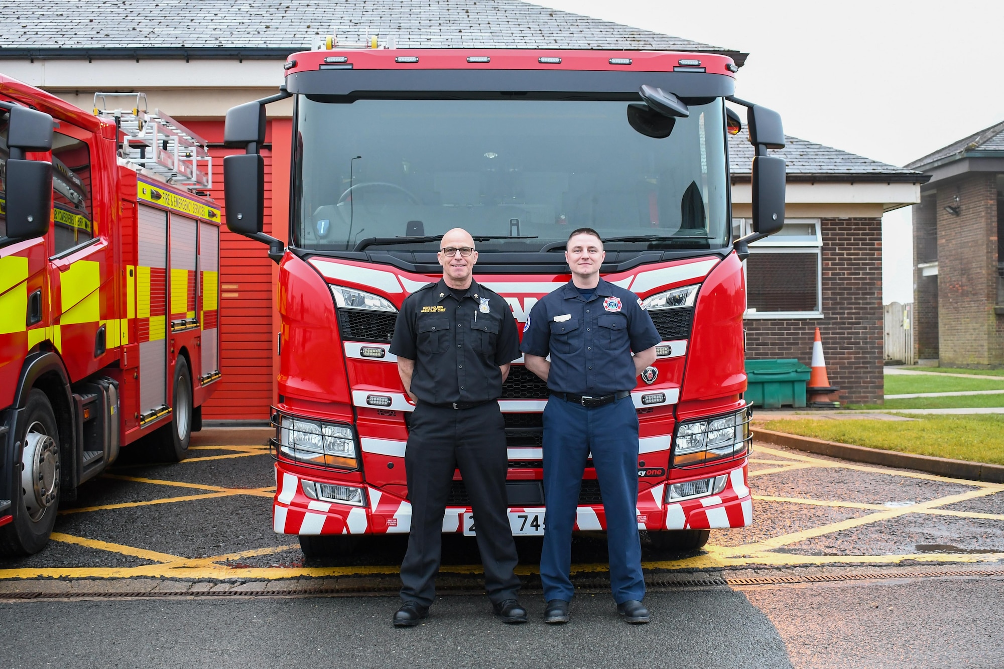 Dave Holmes, 421st Civil Engineer Flight (CEF) Fire and Emergency Services (F&ES) assistant chief, left, and Simon Costella, 421st CEF F&ES crew manager, right, pose for a photo