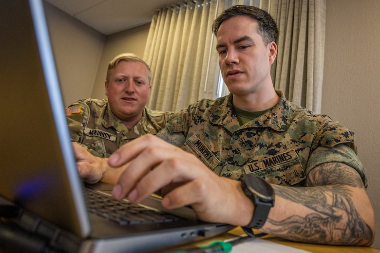 U.S. Army Capt. William McKinnon, left, cyber mission element lead, Florida Army National Guard, and U.S. Marine Corps Sgt. Thane Murphy, intelligence analyst, Defensive Cyberspace Operations Internal Defensive Measures, work through simulated cyber threats during exercise Southern Defender 25 in Augusta, Georgia, May 6, 2025. This exercise pushes teams to identify vulnerabilities, respond to adversary injects, and coordinate actions across 28 teams in 15 locations consisting of 20 participating countries in real time. (U.S. Marine Corps photo by Sgt. Samuel Qin)