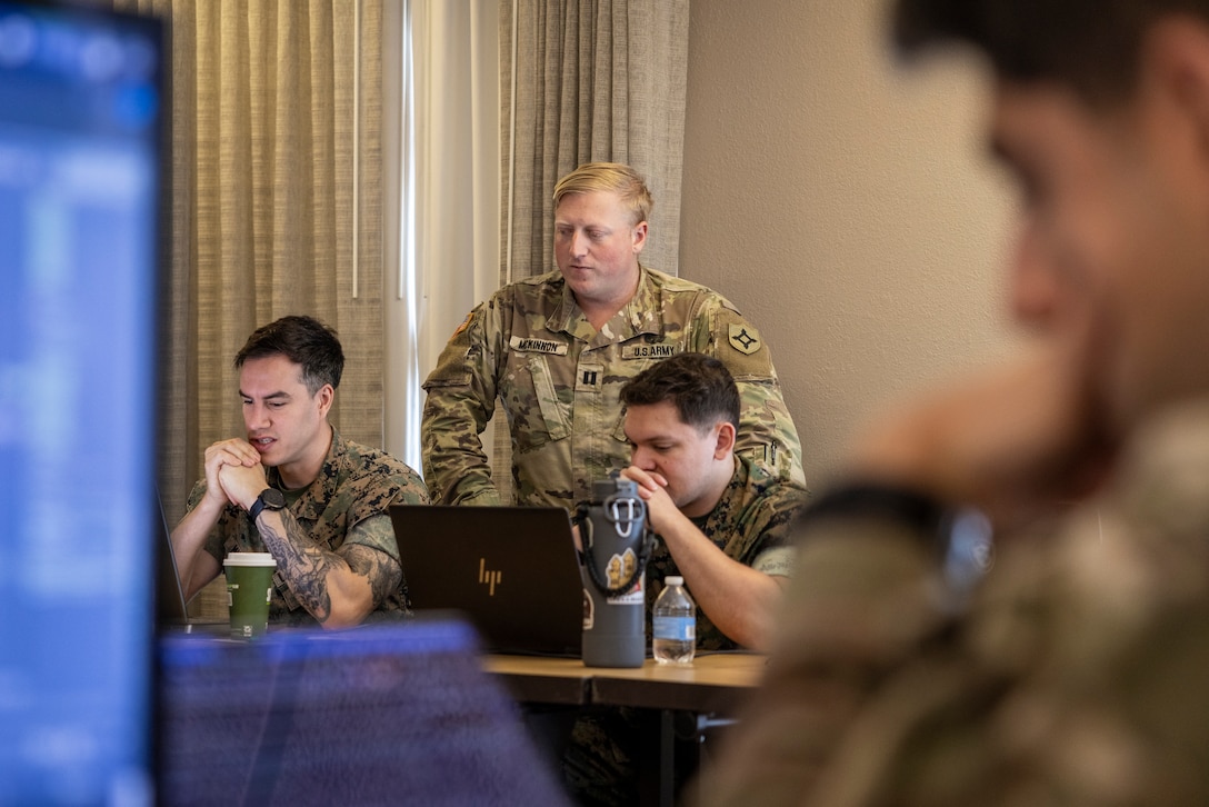 U.S. Marine Corps Sgt. Thane Murphy, intelligence analyst, and Sgt. Victor Navarro, right, cyber warfare operator, Defensive Cyberspace Operations Internal Defensive Measures, and U.S. Army Capt. William McKinnon, center, cyber mission element lead, Florida Army National Guard, conduct defensive cyber operations during exercise Southern Defender 25 in Augusta, Georgia, May 6, 2025. SD 25 is a defensive cyberspace operations focused exercise designed for the U.S. and Allies and partners to collectively strengthen cyberspace awareness, exercise joint all domain operations and counter harmful actors while building multi-lateral capacity. (U.S. Marine Corps photo by Sgt. Samuel Qin)