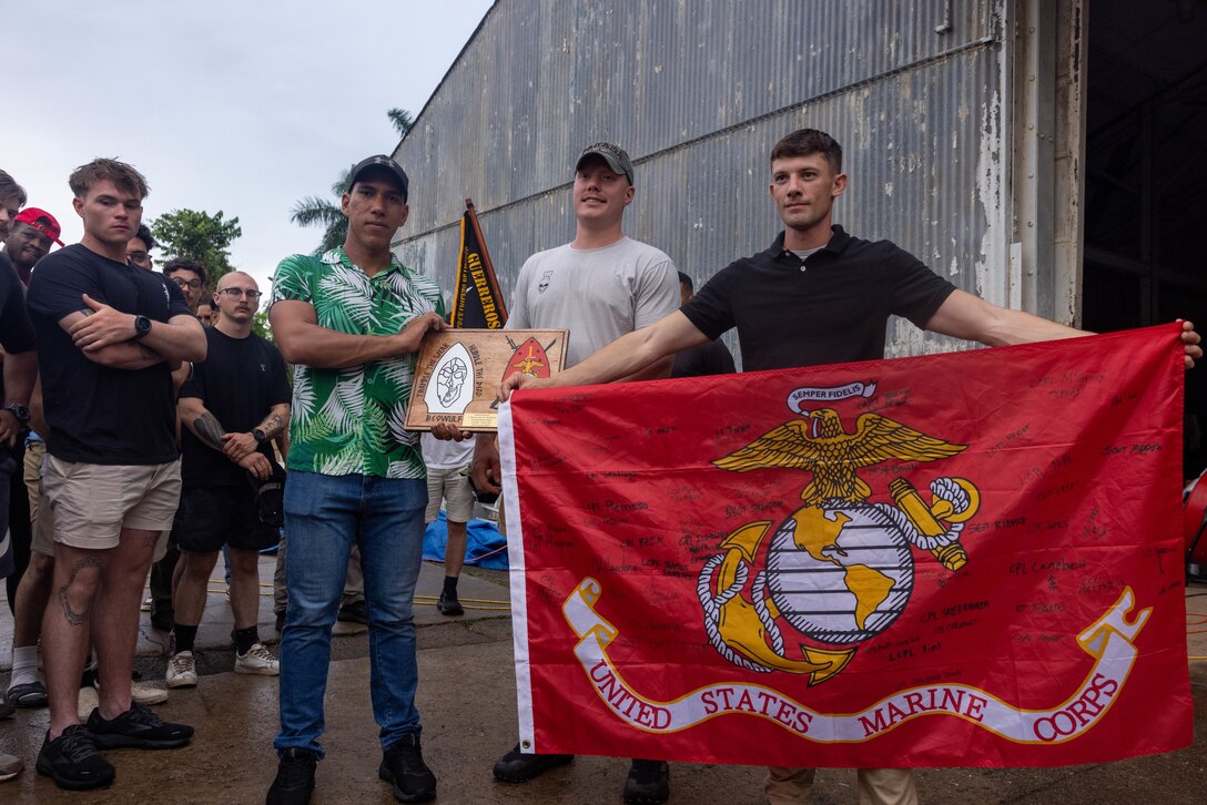 U.S. Marine Corps 1st Lt. Joshua Tiren, left, a Germantown, Maryland native and Staff Sgt. James Sheldon, a Klamath Falls, Oregon native both with 1st Battalion, 8th Marines, 6th Regiment, 2d Marine Division gives a Panamanian security force member a plaque and Marine Corps flag to commemorate training together in Rodman, Panama, May 2, 2025. U.S. Southern Command is focused on increasing partner nation capacity and interoperability in the region and reflects the United States’ enduring promise of friendship, partnership, and solidarity with the Panamanian people. (U.S. Marine Corps photo by Lance Cpl. Francis Hrosar)