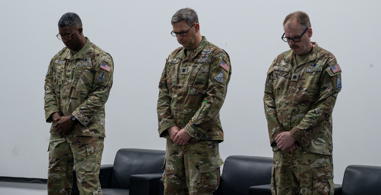 From the left, U.S. Space Force Col. Frank Brooks, U.S. Space Force Central deputy commander, Lt. Col. Dustin Guidry, outgoing commander and Lt. Col. Kyle Keith, incoming commander, bow their heads during a change of command ceremony within the U.S. Central Command area of responsibility, May 8, 2025. Combat Detachment 3-1 has supported Space Force Central Command by deploying battle-ready Guardians since 2024. (U.S. Air Force photo by Senior Airman Dieondiere Jefferies)