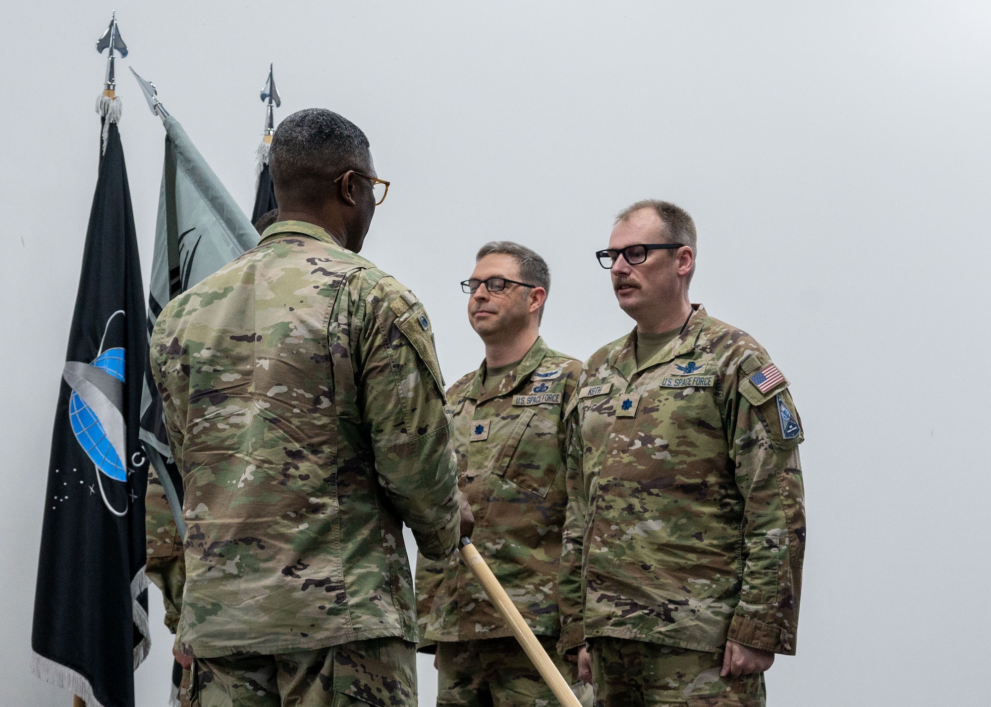 U.S. Space Force Lt. Col. Kyle Keith, right, Combat Detachment 3-1 incoming commander, prepares to receive the guidon from Col. Frank Brooks, U.S. Space Force Central deputy commander, during a change of command ceremony within the U.S. Central Command area of responsibility, May 8, 2025. Since 2024, Combat Detachment 3-1 has supported Space Force Central Command by ensuring the deployment of battle-ready Guardians. (U.S. Air Force photo by Senior Airman Dieondiere Jefferies)