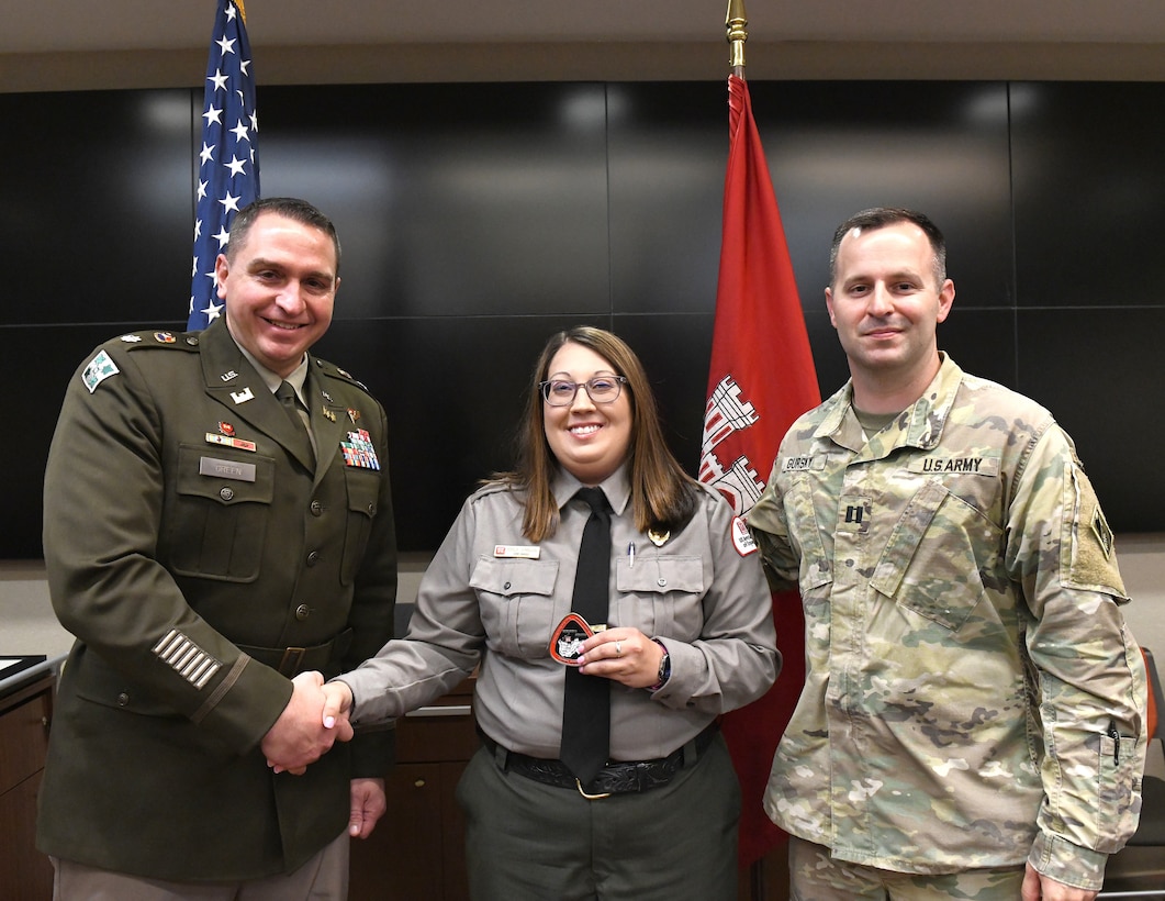 Lt. Col. Robert Green, U.S. Army Corps of Engineers Nashville District commander, left, presents a commander’s coin to Conservation Biologist Emily Johnson of Old Hickory Lake as Capt. Matthew Gursky, right, looks on May 5, 2025, in Nashville, Tenn. Johnson was honored for her leadership in use-fee management and mentorship of new employees. (USACE Photo by Noe Gonzalez)