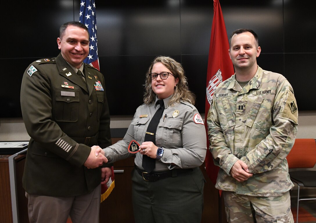 Lt. Col. Robert Green, U.S. Army Corps of Engineers Nashville District commander, left, presents a commander’s coin to Environmental Protection Specialist Ashley Webster of Cordell Hull Lake as Capt. Matthew Gursky, right, looks on May 5, 2025, in Nashville, Tenn. Webster was honored for her contributions to water safety public service announcements and training efforts during the district’s 2024 safety program. (USACE Photo by Noe Gonzalez)