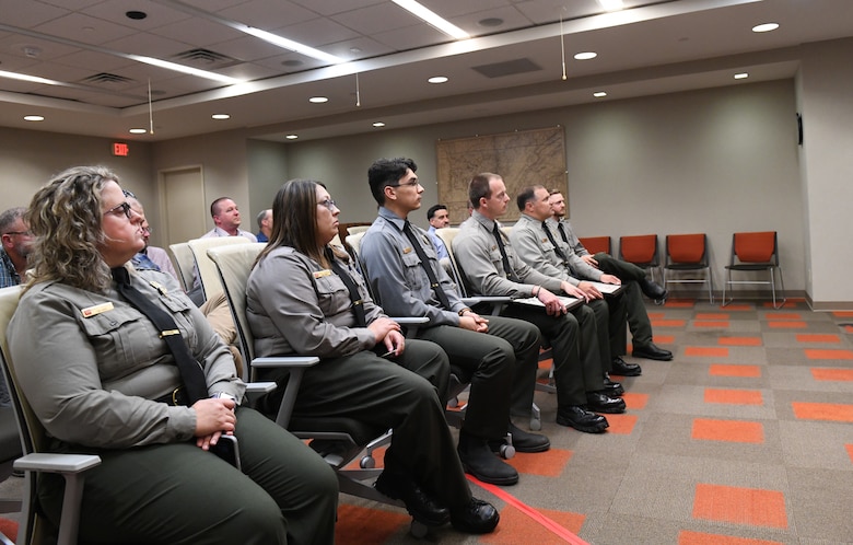 Six U.S. Army Corps of Engineers Nashville District park rangers listen as Lt. Col. Robert Green, district commander, speaks during a recognition ceremony May 5, 2025, in Nashville, Tenn. The rangers were honored for their outstanding contributions to natural resource management, public safety and ranger training. District leaders look on from the back of the room (USACE Photo by Noe Gonzalez)