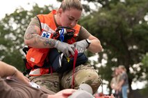 A white female Airman from the 628th Medical Group prepare to check the vitals of a patient during a medical exercise.
