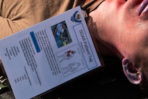 A white male lays on the ground during a medical exercise.