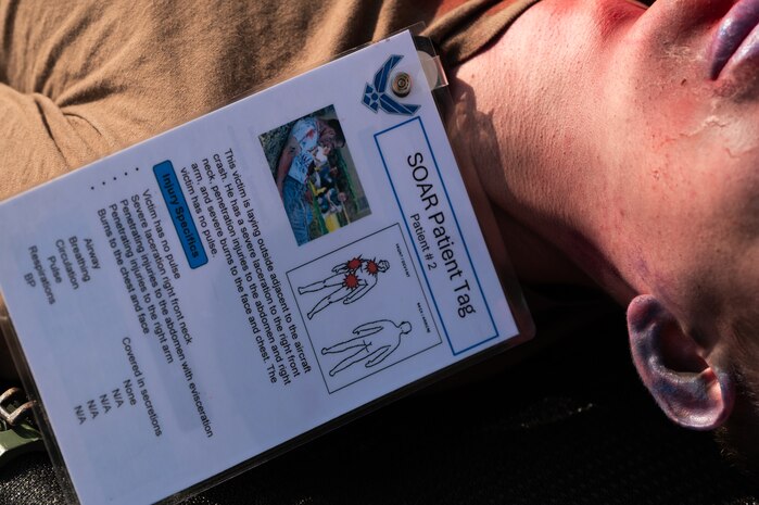 A white male lays on the ground during a medical exercise.