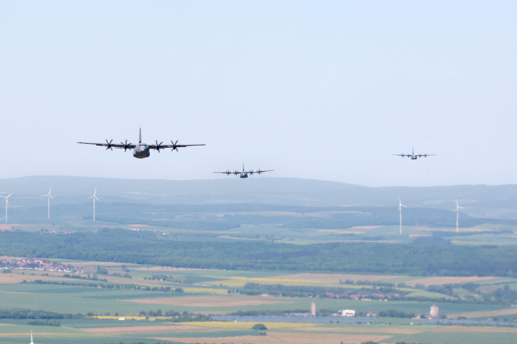 Three C-130J Super Hercules aircraft fly in a formation