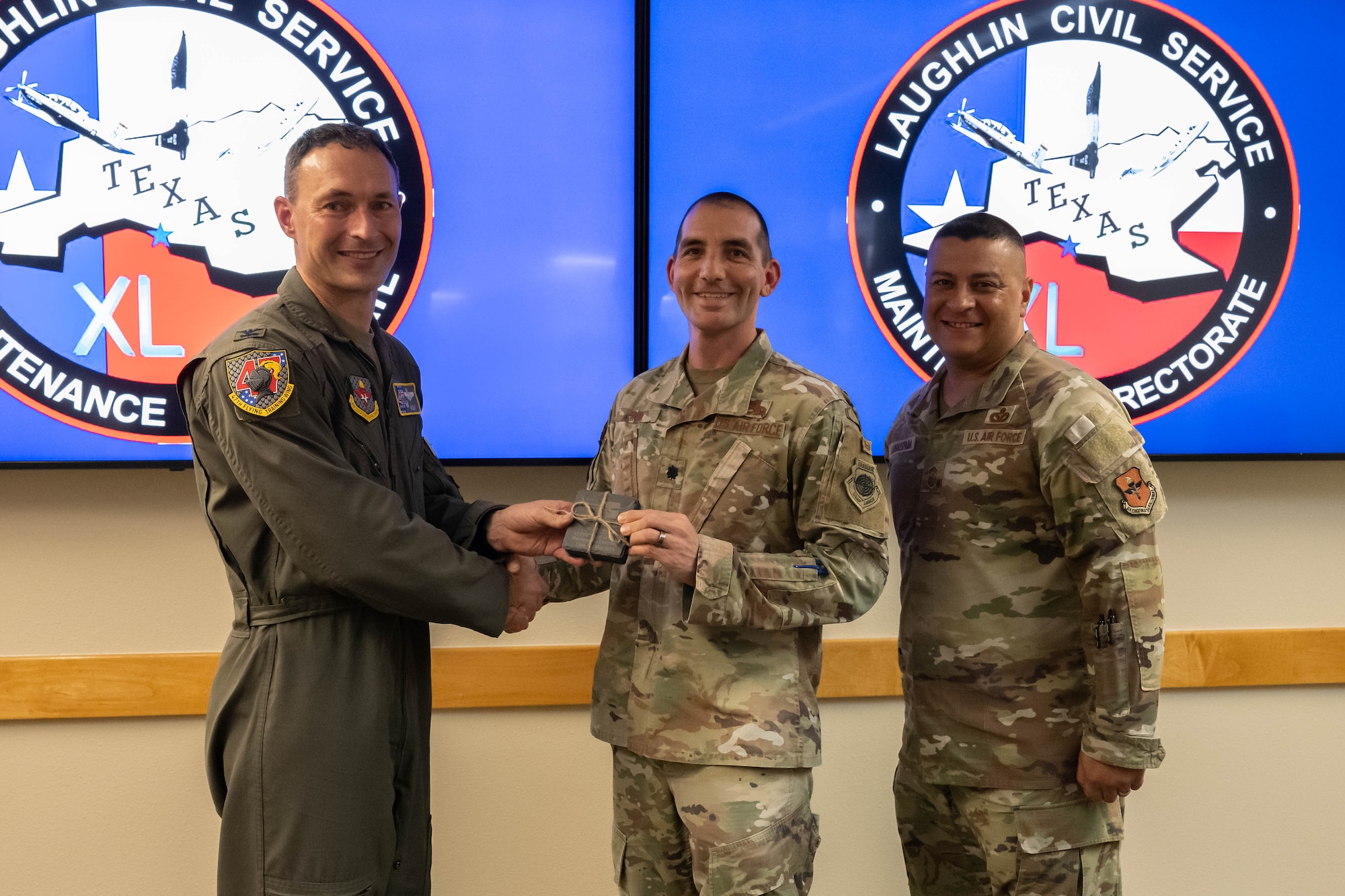 U.S. Air Force Col. Tyler Ellison, 47th Flying Training Wing commander, and Chief Master Sgt. Lester Largaespada, 47th FTW command chief, present a first quarter award at Laughlin Air Force Base, May 2, 2025. The quarterly awards ceremony honored Airmen and civilians who demonstrated exceptional performance, leadership, and mission impact across the wing. (U.S. Air Force photo by Airman 1st lass Harrison Sullivan)