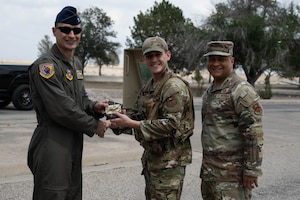 U.S. Air Force Col. Tyler Ellison, 47th Flying Training Wing commander, and Chief Master Sgt. Lester J. Largaespada, 47th FTW command chief, present a first quarter award at Laughlin Air Force Base, May 2, 2025. The quarterly awards ceremony honored Airmen and civilians who demonstrated exceptional performance, leadership, and mission impact across the wing. (U.S. Air Force photo by Airman 1st lass Harrison Sullivan)