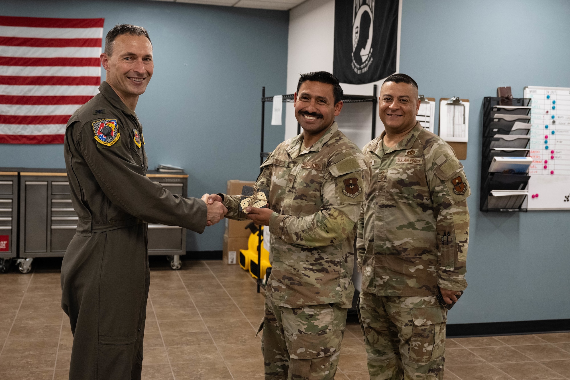 U.S. Air Force Col. Tyler Ellison, 47th Flying Training Wing commander, and Chief Master Sgt. Lester J. Largaespada, 47th FTW command chief, present a first quarter award at Laughlin Air Force Base, May 2, 2025. The quarterly awards ceremony honored Airmen and civilians who demonstrated exceptional performance, leadership, and mission impact across the wing. (U.S. Air Force photo by Airman 1st lass Harrison Sullivan)