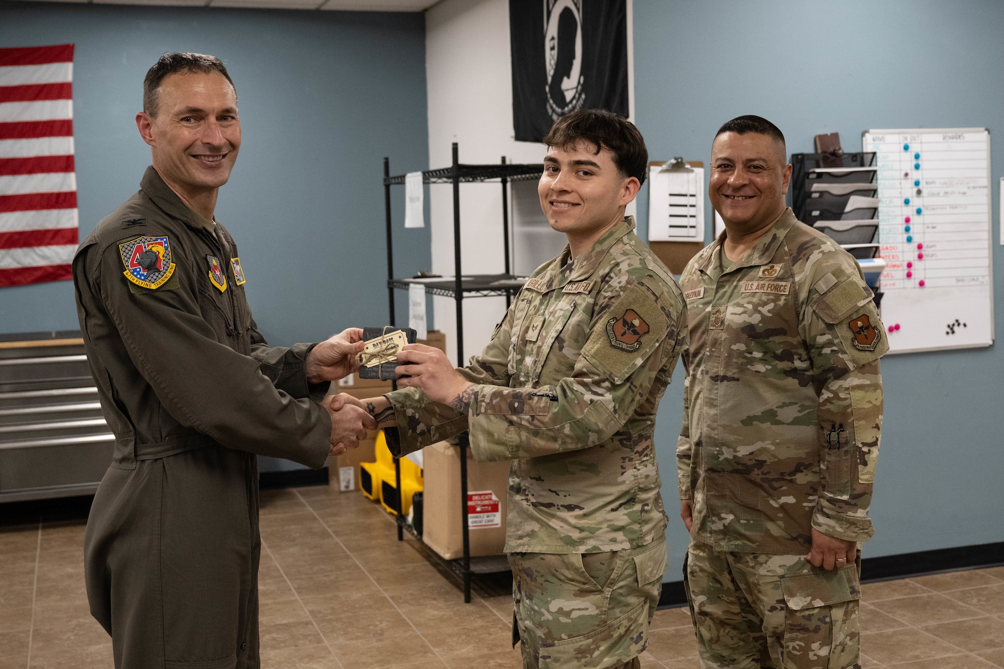 U.S. Air Force Col. Tyler Ellison, 47th Flying Training Wing commander, and Chief Master Sgt. Lester J. Largaespada, 47th FTW command chief, present a first quarter award at Laughlin Air Force Base, May 2, 2025. The quarterly awards ceremony honored Airmen and civilians who demonstrated exceptional performance, leadership, and mission impact across the wing. (U.S. Air Force photo by Airman 1st lass Harrison Sullivan)